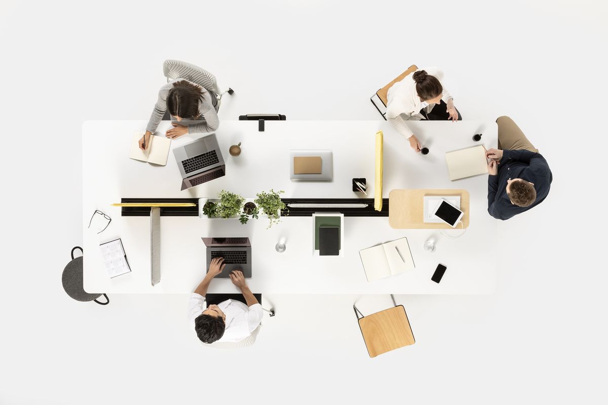 A team collaborating around a desk, viewed from above